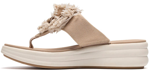 A tan flip-flop with a thick white sole and a decorative tan flower on the strap.