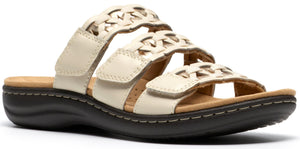 Off-white sandal with three straps, each with a woven design and velcro closure.