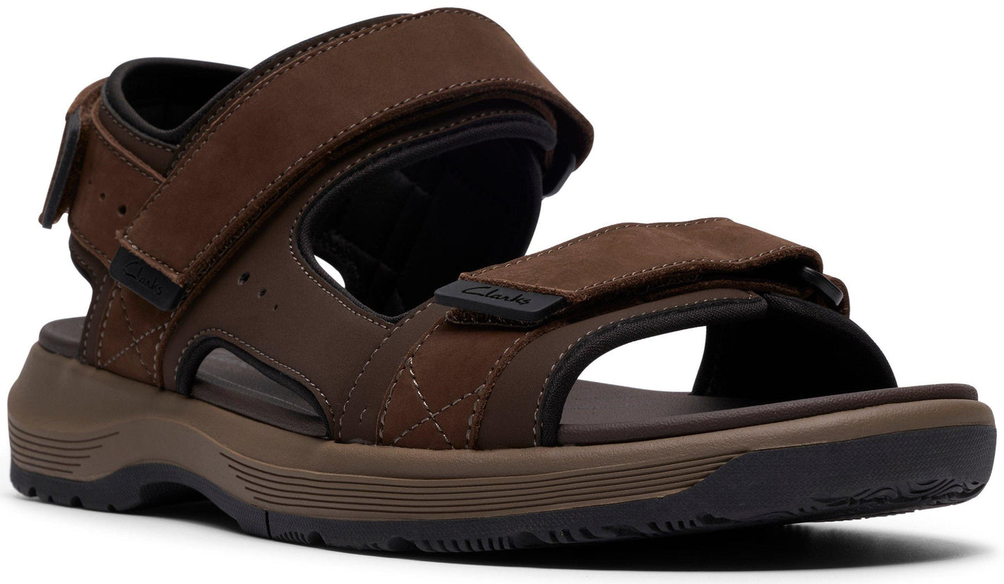 A brown sandal with velcro straps and a thick sole.