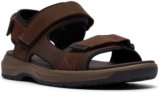 A brown sandal with velcro straps and a thick sole.