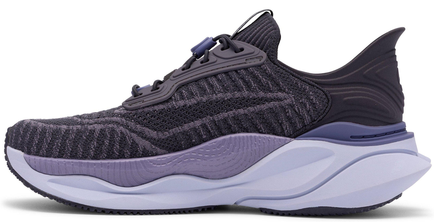 Side view of a dark grey running shoe with a lavender accent and a thick white sole.