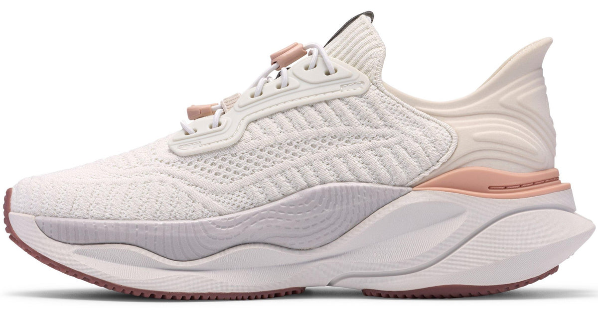 A women's white running shoe with a thick white sole and rose gold accents.