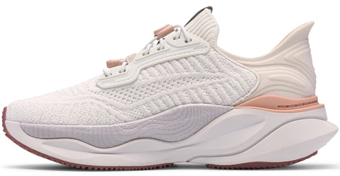 A women's white running shoe with a thick white sole and rose gold accents.