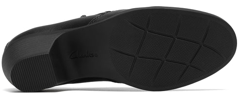 The black textured rubber outsole of a shoe with a low block heel.