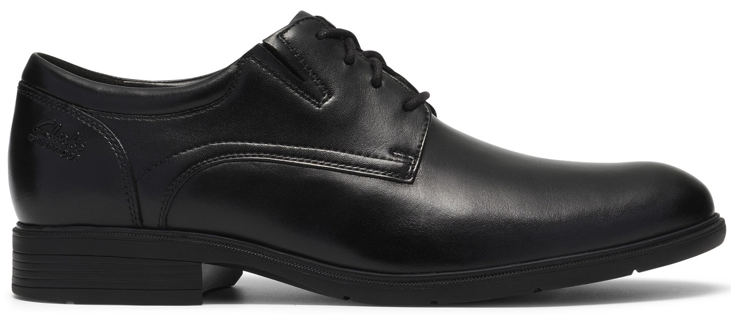 A black leather men's dress shoe with a round toe, lace-up closure, low heel, and minimalist stitching details on the side.