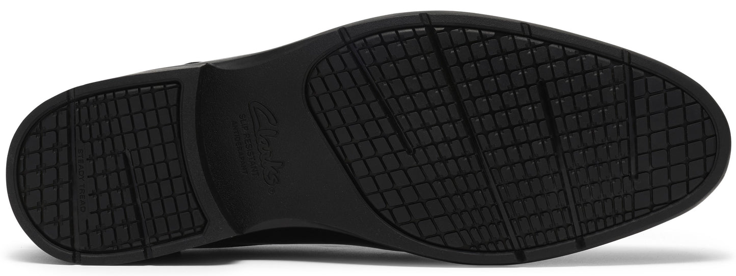 The bottom sole of a black shoe features a patterned grid tread design with subtle diagonal grooves for traction and a faintly embossed logo in the center arch.