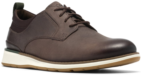 A brown leather lace-up shoe with a white midsole and light brown rubber outsole, featuring a green pull tab at the heel.