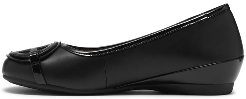 A black, slip-on ballet flat shoe with a low, wedge heel, featuring a decorative patent leather strap detail across the rounded toe.