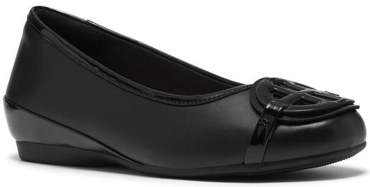 A black slip-on flat shoe with a smooth leather finish and a prominent circular logo cutout ornament on the rounded toe.