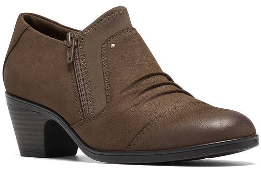 A brown, synthetic leather ankle bootie with a low stacked heel, rounded toe, side zipper, and subtle ruched detailing across the vamp.