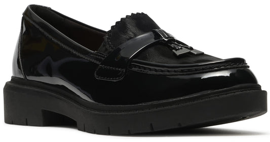 A black patent leather loafer with a thick, lugged rubber sole, featuring a notched vamp strap with a decorative tassel detail.