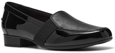 A black slip-on loafer with a low block heel, featuring a combination of smooth patent leather at the heel and toe, and a textured, cross-hatched pattern on the upper, accented by a wide black elastic band across the instep.