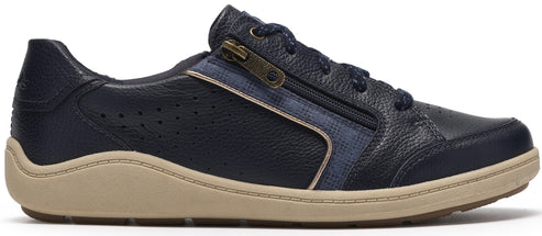 A navy blue leather sneaker with a side zipper, featuring perforated side panels, navy blue laces, and a thick, wavy-edged tan rubber sole.