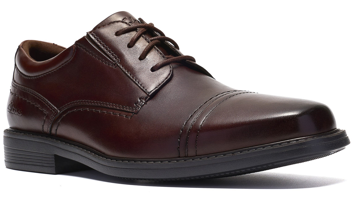 A dark brown leather cap-toe oxford dress shoe with laces and a sturdy, dark grey sole.