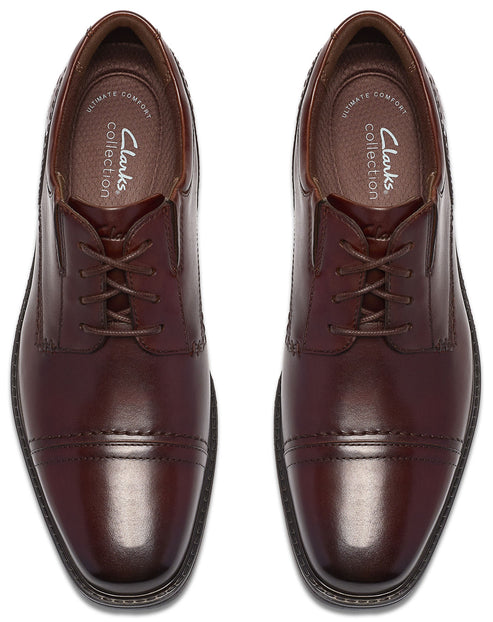 A pair of dark brown leather oxford-style dress shoes with cap toes and laces, viewed from directly above, showing the Clarks Collection logo on the inner footbeds.