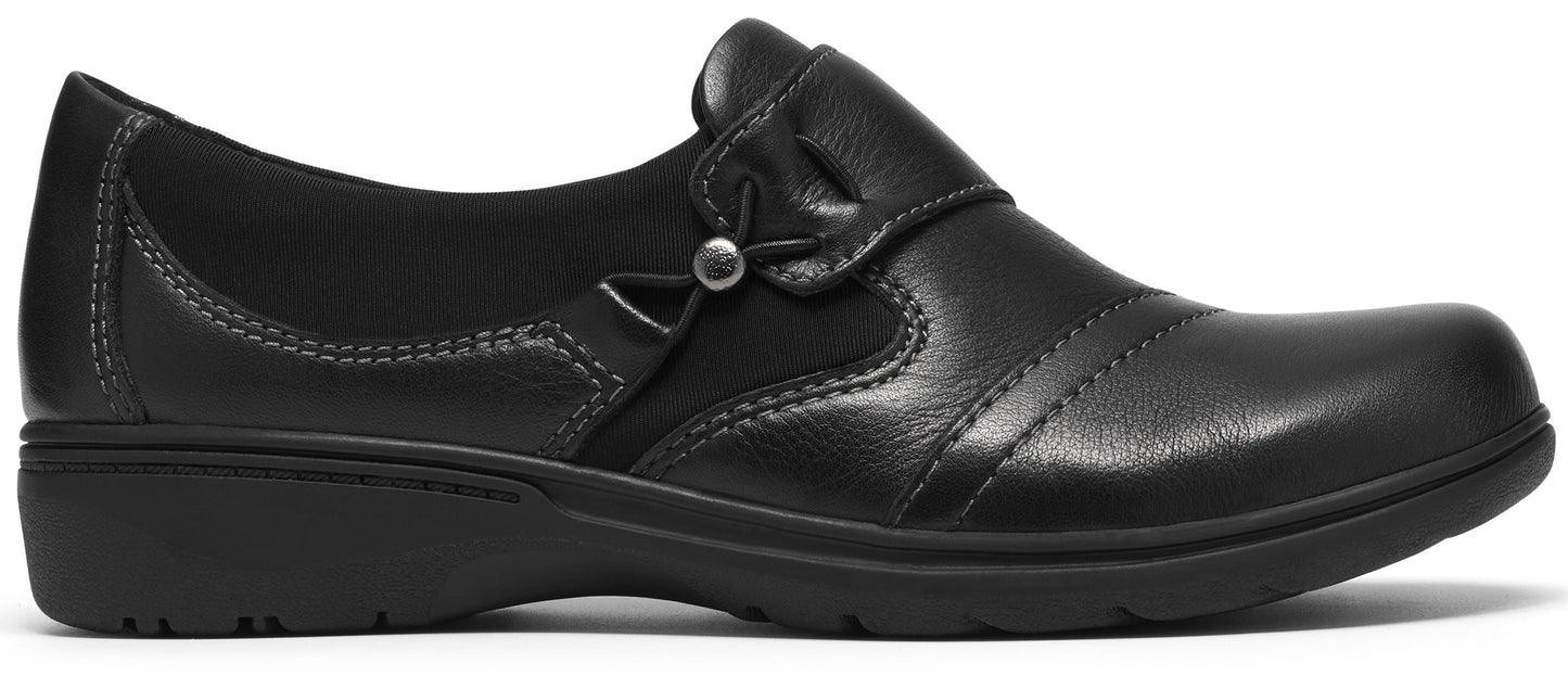 A black leather slip-on shoe with a low wedge heel, featuring a decorative side button and elastic goring.
