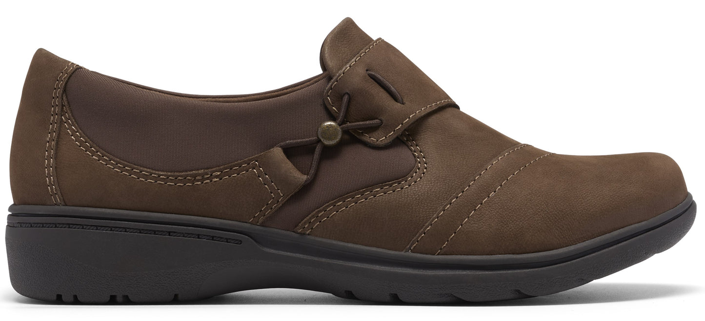 A brown, slip-on comfort shoe with a round toe, side-stitch detailing, a small decorative metal stud on the side, and a dark brown, flat, flexible rubber sole.