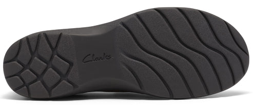 A black, textured shoe sole with a geometric tread pattern at the heel and wavy, horizontal grooves across the rest of the surface, featuring the word Clarks embossed in the center.
