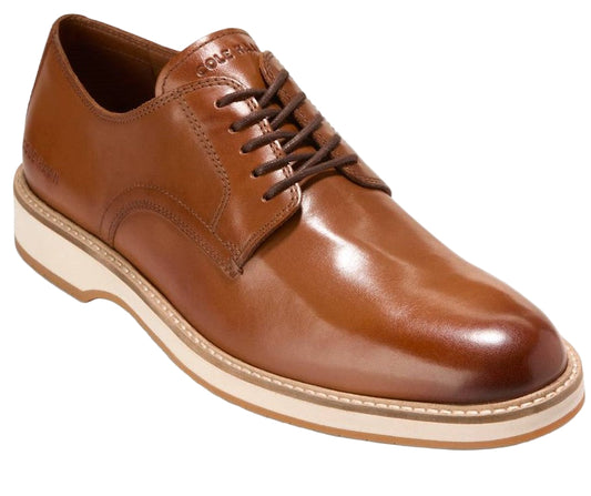 A shiny brown leather dress shoe with brown laces and a thick, white sole.