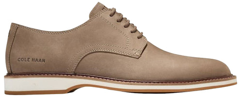 A tan-colored leather dress shoe with white and brown soles and COLE HAAN printed on the heel.