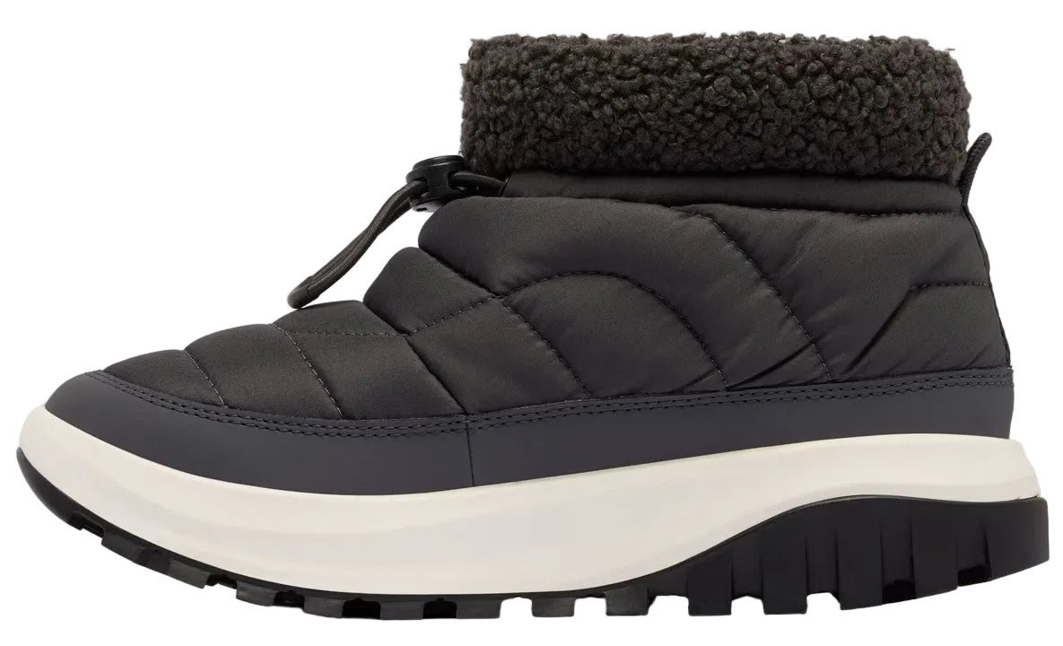A black quilted ankle boot with a charcoal gray sherpa fleece collar, a toggle lace closure at the front, a chunky white midsole, and a black lugged rubber outsole.