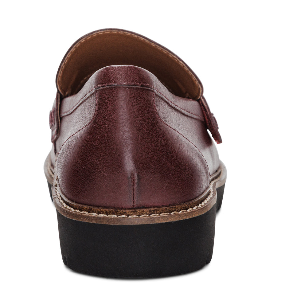 Burgundy leather loafer with a black lug sole, viewed from the back.