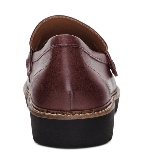 Burgundy leather loafer with a black lug sole, viewed from the back.