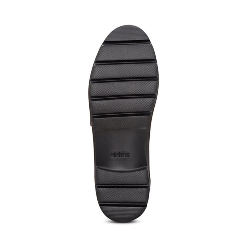 Black lug outsole of a shoe.