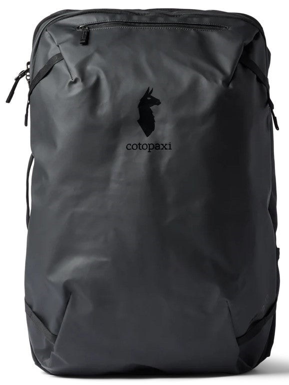A sleek, black, rectangular, weather-resistant travel backpack with a vertical zipper pocket on the front and the Cotopaxi llama logo and brand name printed in the center.