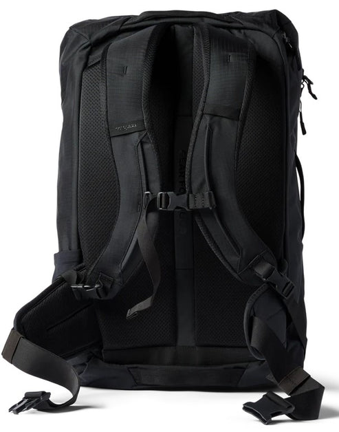 A back view of a solid black travel backpack showing the mesh-padded shoulder straps, an adjustable sternum strap, and a padded hip belt with buckle closures.