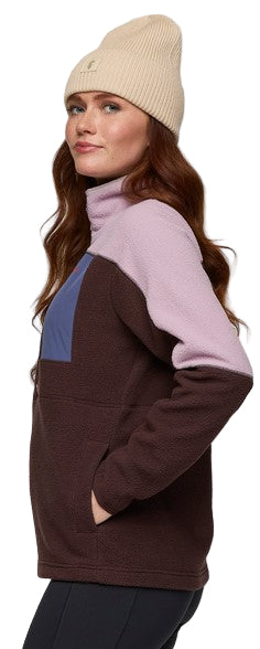A woman wearing a color-block turtleneck fleece and a beige beanie.