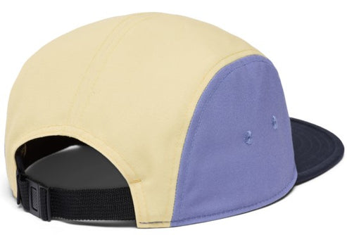 Color-blocked, five-panel baseball cap: front and top panels are light yellow, side panels are light purple, and brim is black, with a black adjustable strap.