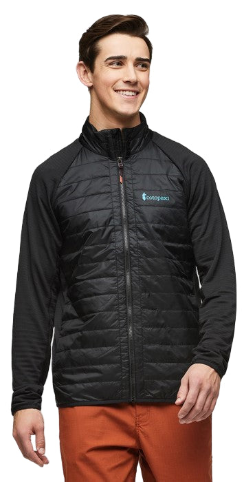 A person wearing a black quilted jacket with long sleeves, zipped up. There is a logo on the upper right side of the jacket.