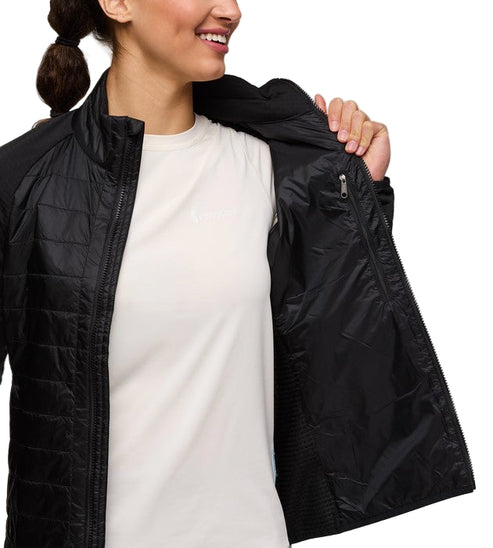 A woman wearing a black quilted jacket over a white t-shirt.