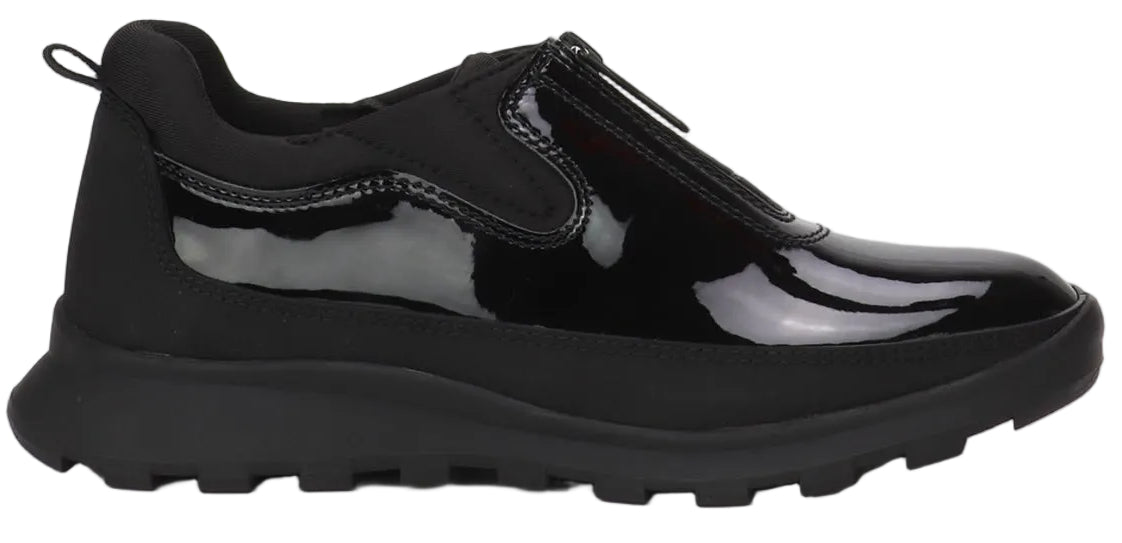 A black slip-on sneaker featuring a patent leather upper with a front zipper closure, a padded collar, and a thick, lugged rubber sole.