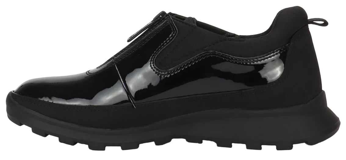 A black sneaker with a glossy patent leather upper featuring a front zipper closure, set on a chunky, ridged black rubber lug sole.