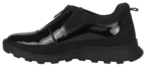 A black sneaker with a glossy patent leather upper featuring a front zipper closure, set on a chunky, ridged black rubber lug sole.