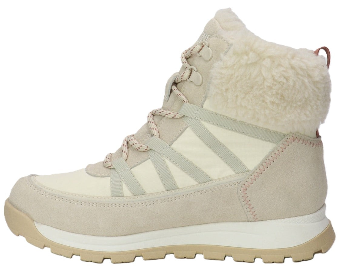 A light beige, lace-up winter boot featuring a textured, fuzzy white faux-fur cuff, a white and cream fabric upper, tonal suede overlays, and a thick, ridged light tan sole.