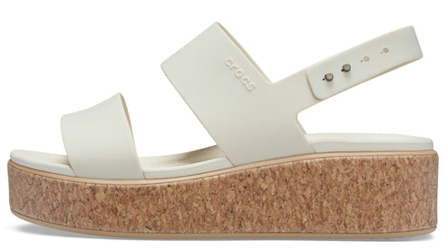 A platform sandal with two wide, white straps over the foot, an ankle strap, and a cork platform.