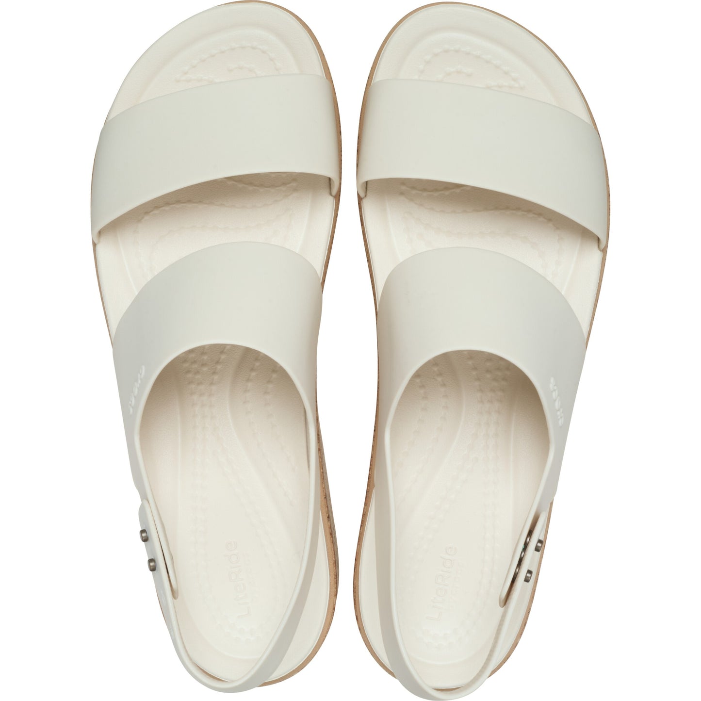 Overhead shot of two white sandals, each with two straps, one across the toes and one across the arch of the foot. Both sandals have heel straps.