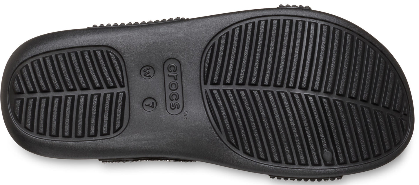Close-up of the sole of a black shoe with linear tread patterns.