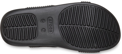 Close-up of the sole of a black shoe with linear tread patterns.
