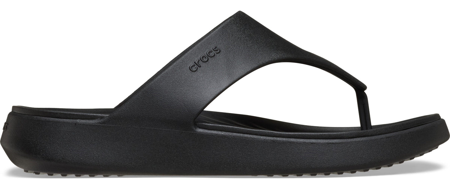A black flip-flop with the brand name Crocs on the side.