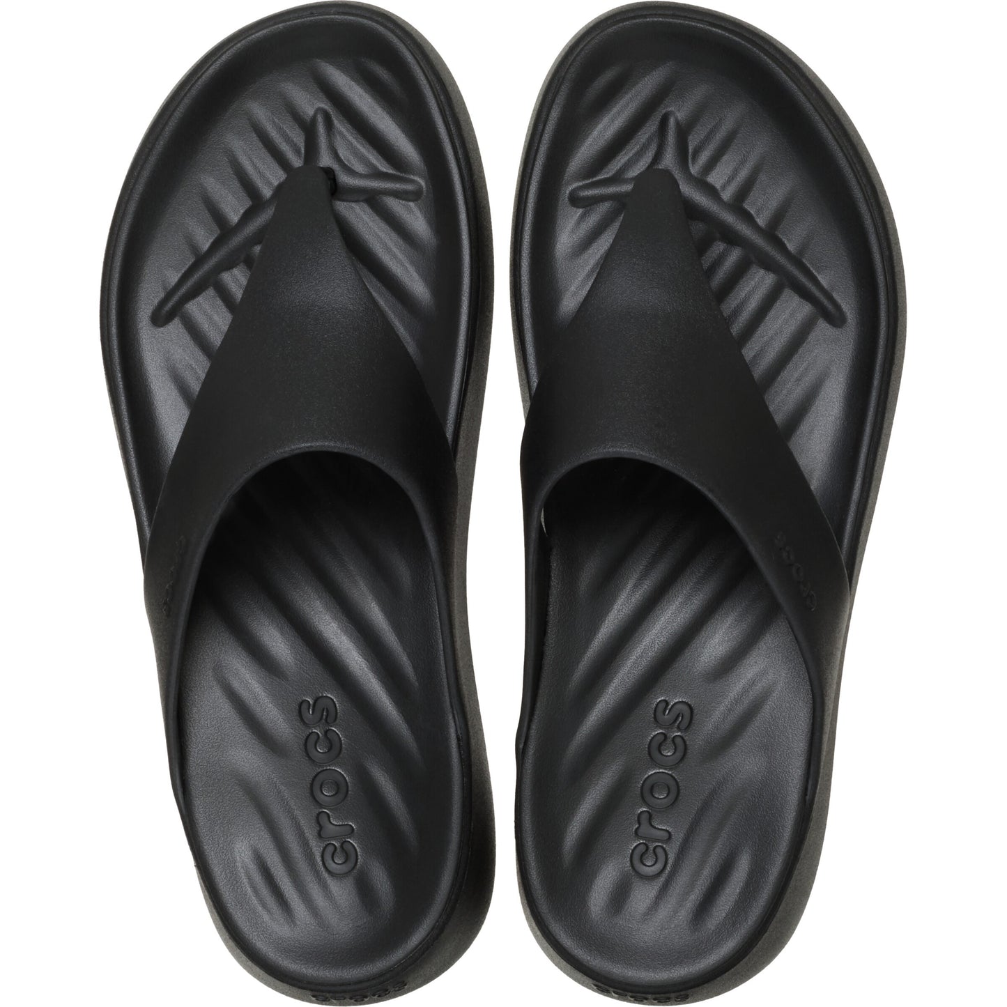 Black flip-flops with 'crocs' written on the soles, view from above.