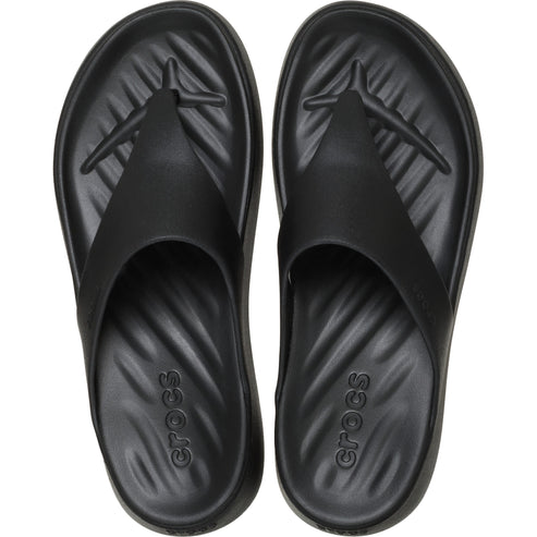 Black flip-flops with 'crocs' written on the soles, view from above.