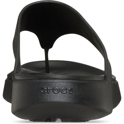 Close-up back view of a black flip-flop sandal, featuring a rounded, elevated sole with embossed 'crocs' text.