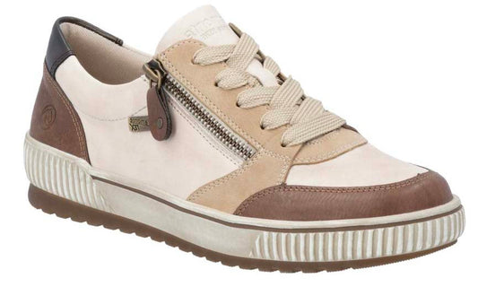 Low-top sneaker with zipper and laces, featuring panels of brown, tan, and cream-colored leather, set on a ridged sole.