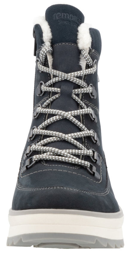 Front view of a dark-blue ankle boot with white laces, faux fur lining at the top, and a thick white sole.