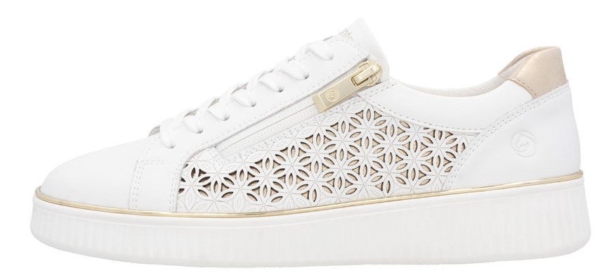 White sneaker with gold accents and floral cutouts on the side.