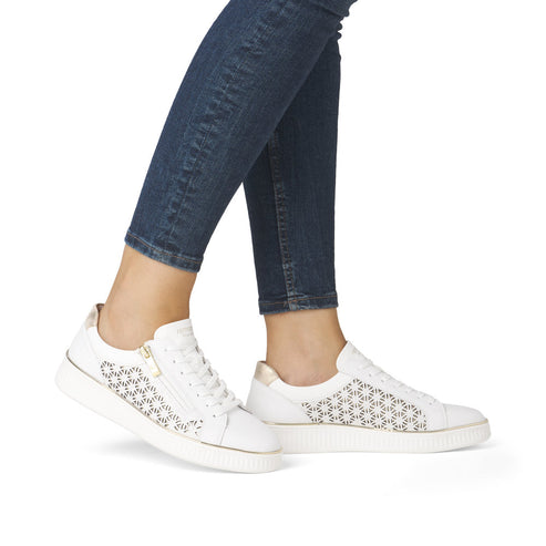 Person wearing white sneakers with perforated detailing.